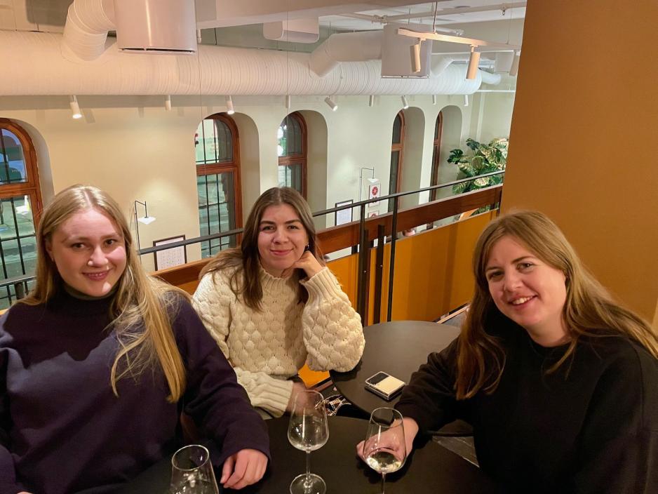 Tre venninner sitter sammen p&aring; bar