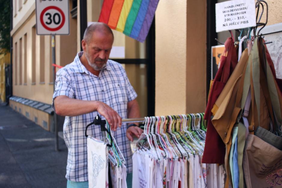 Vidar sorterer de broderte dukene pent p&aring; stativene 