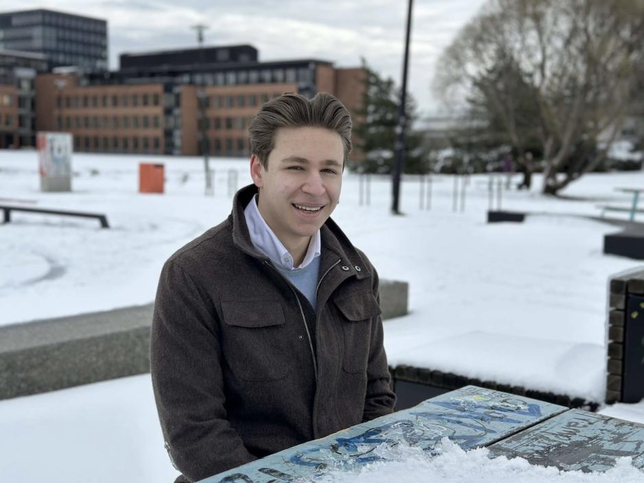 En ung gutt som sitter p&aring; en benk