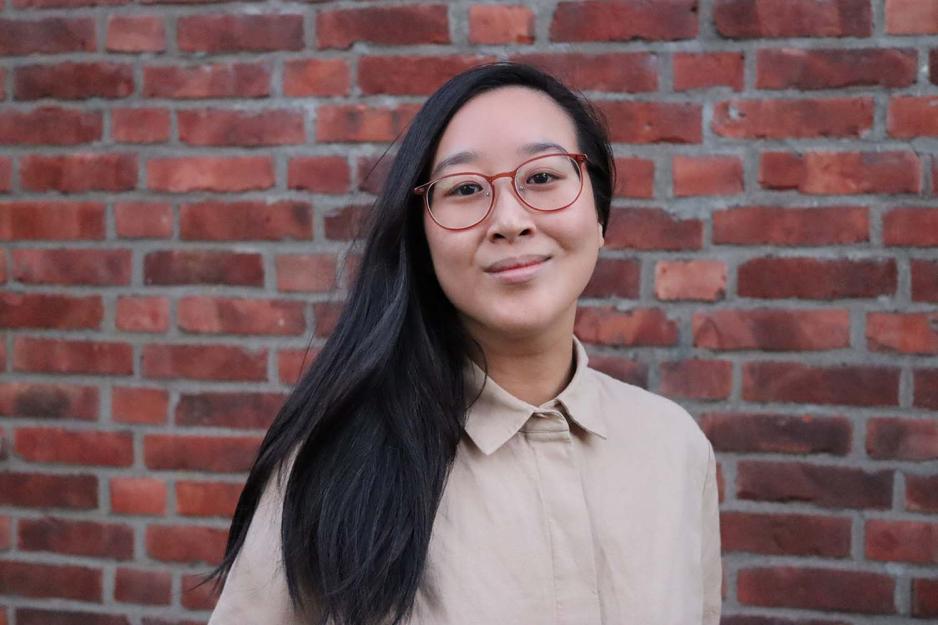 Xueqi Pang er foran en r&oslash;d murvegg