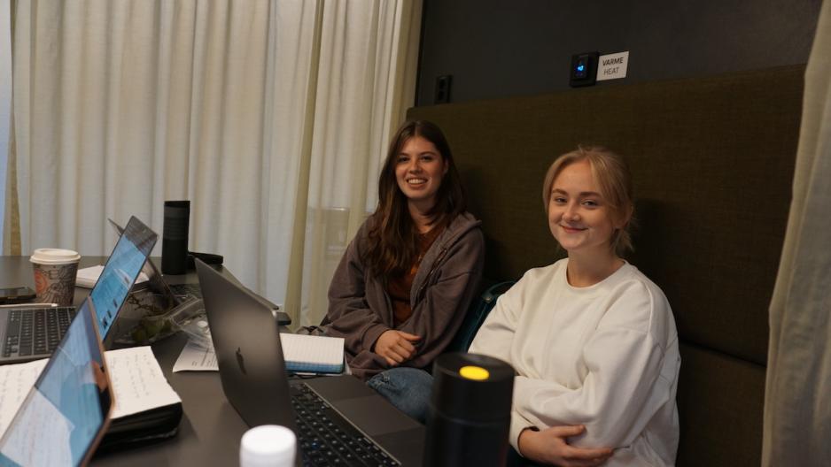 To kvinnelige studenter sitter p&aring; OsloMET i noen sofaer og jobber med skole. 