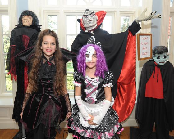 to barn og to voksne har kledd seg ut i halloweenkostymer. De st&aring;r i en gang. 