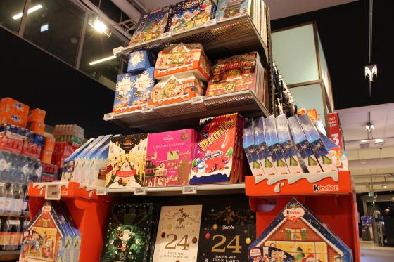 En hylle full av adventskalendere p&aring; en matbutikk. Det er ulike adventskalendere med godteri i. 