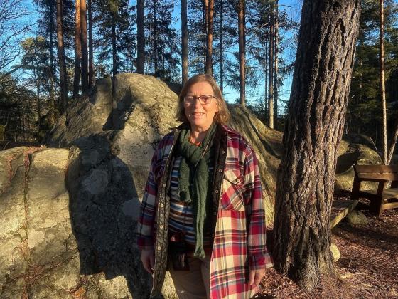Helga Gunnarsd&oacute;ttir, styreleder i &Oslash;stmarkas venner st&aring;r i sollyset i skogen