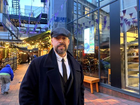 Mikael Diseth st&aring;r mellom to restauranter og smiler skjevt til kamera.