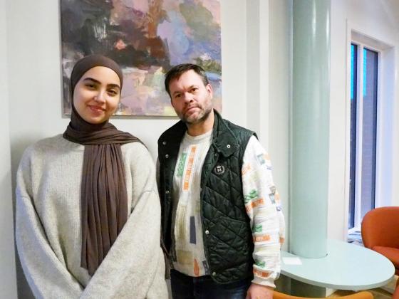 En man og en kvinne st&aring;r ved siden av hverandre. De er avbildet foran et maleri.