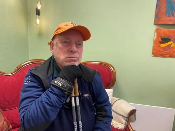 Halvn&aelig;rt bilde av eldre mann som sitter i r&oslash;d sofa. 