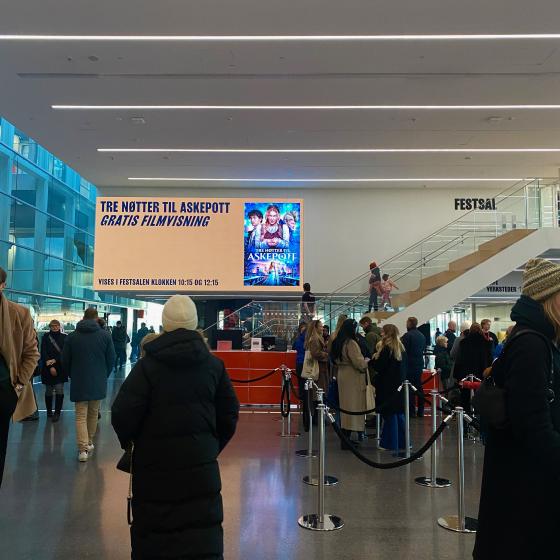 Det er k&oslash; i lobbyen p&aring; Munchmuseet. I bakgrunnen ser man en stor plakat med informasjon om jule&aring;pningen