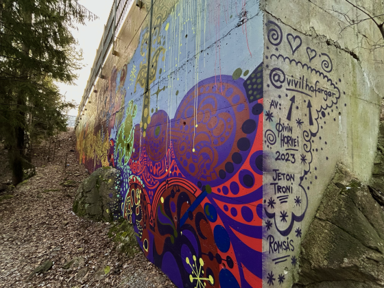 P&aring; hj&oslash;rnet av veggen har kunsterne signert kunstverket.