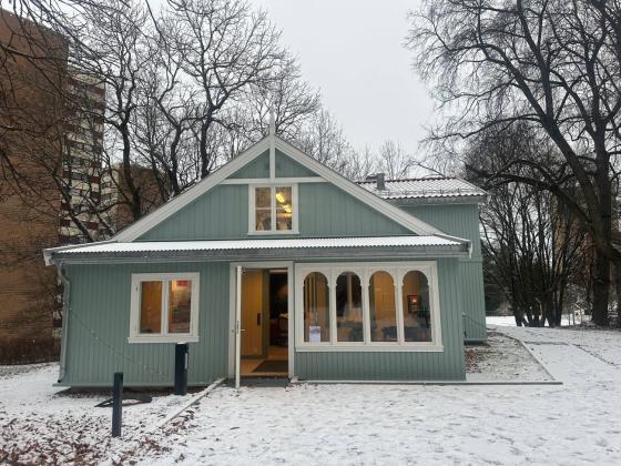 Det restaurerte Nabolagshuset fra forsiden, &aring;pen d&oslash;r, lys i vinduene