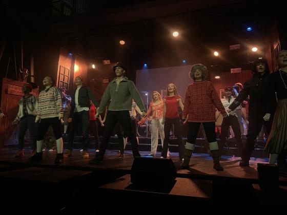 En scene med videreg&aring;ende elever i kostymer som synger og danser