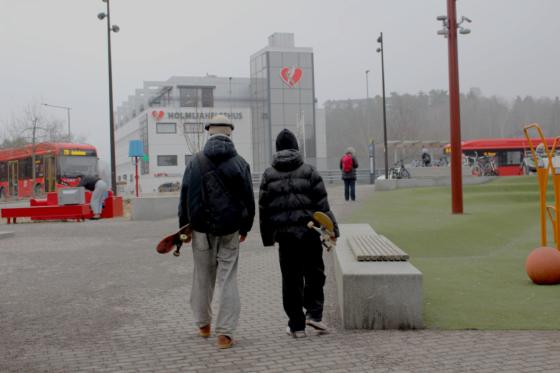 To gutter med ryggen til, som b&aelig;rer hvert sitt skateboard.