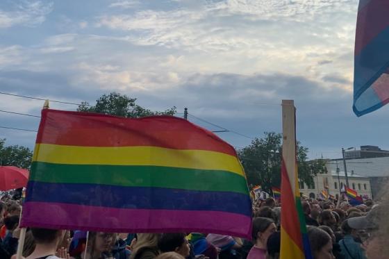 Prideflagg i forgrunnen og mange mennesker i bakgrunnen
