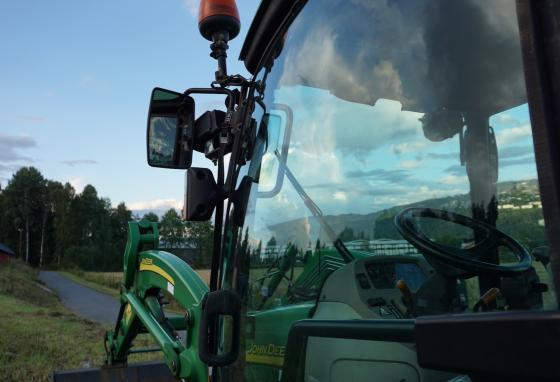 N&aelig;rbilde av f&oslash;rersetet til en traktor ved en &aring;ker i B&aelig;rum