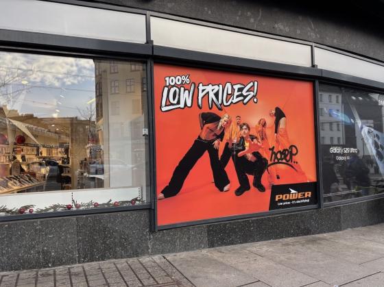 Et reklameskildt for Power hvor det st&aring;r "100% low prices"