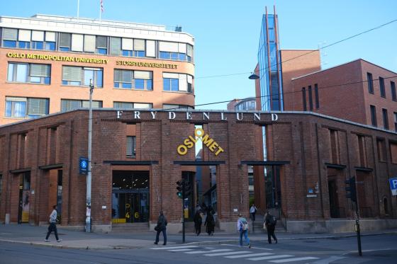 Inngangspartiet til OsloMet i Pilestredet, med studenter som går forbi.