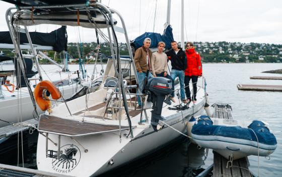 Fire gutter står på siden av seilbåten "sleipner"