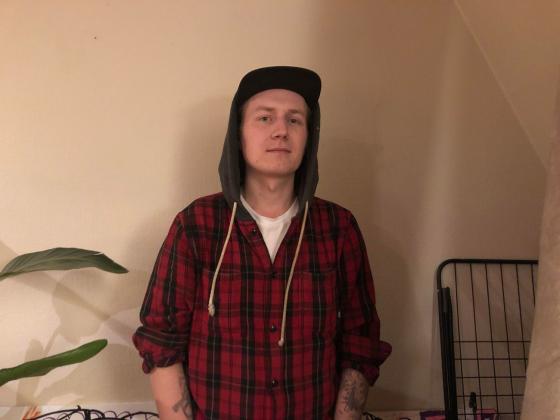 Adrian st&aring;r foran veggen i stuen sin