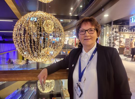 Senterleder p&aring; Storo Storsenter, Unni Merethe Aasgaard, avbildet p&aring; kj&oslash;pesenteret, med butikker og julepynt i bakgrunnen.