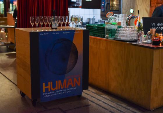 Bilde av glass p&aring; bord med plakat Human