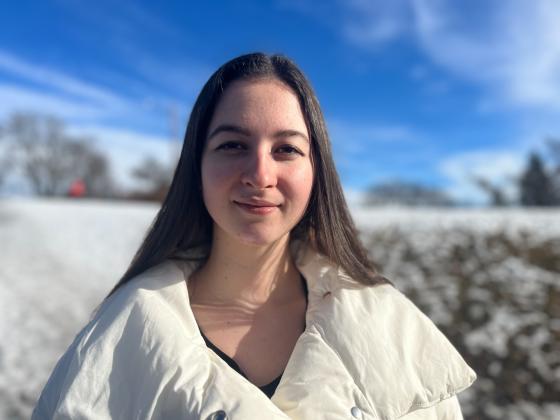 Alona i hvit jakke. Bakgrunn av sn&oslash; og sol