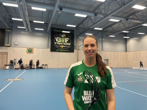 Innebandyspiller med gr&oslash;nn drakt og brunt h&aring;r