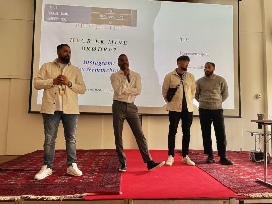 Fire menn fra prosjektet Hvor er mine br&oslash;dre? som holder en presentasjon