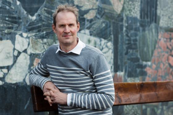 Portrett av en mann, Bj&oslash;rn Olav Jahr, sitter p&aring; en benk.