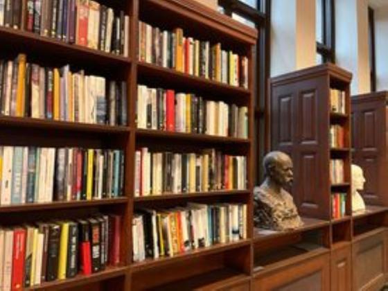 To bokhyller. En statue st&aring;r i midten