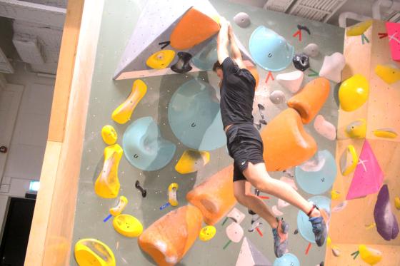 Bilde av en gutt som buldrer p&aring; en fargerik vegg