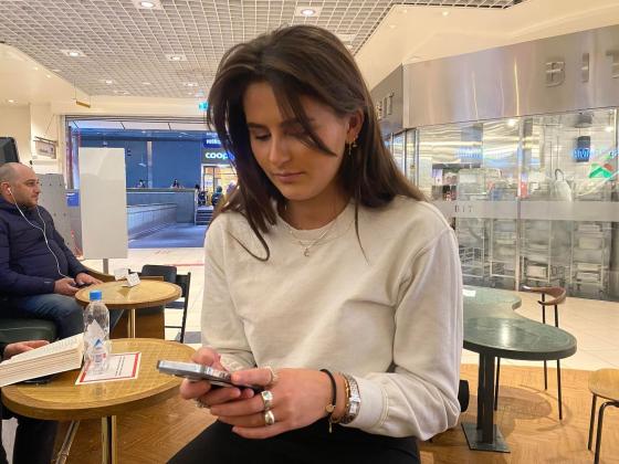 En jente med tlf p&aring; kaf&eacute;