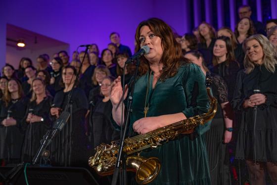 Saxofonist Fr&oslash;ydis Grorud st&aring;r foran koret Gospel explosion