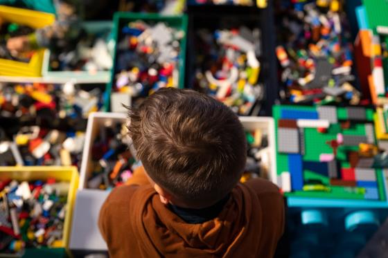 Bildet viser bakhodet til en gutt fra en h&oslash;y vinkel, som ser utover et legobord.