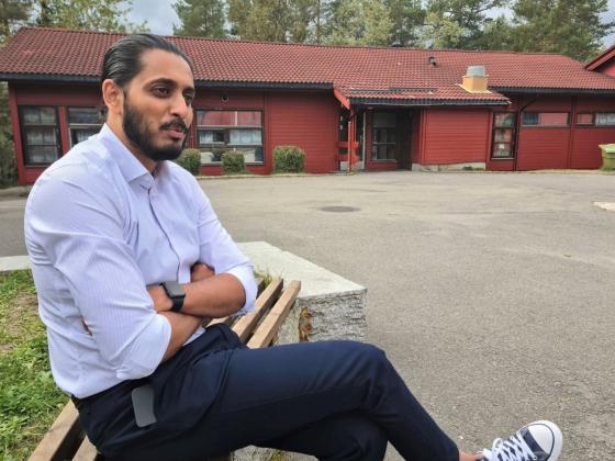 Ap-politiker Farukh Qureshi sitter p&aring; en benk utenfor Bj&oslash;rndal skole.