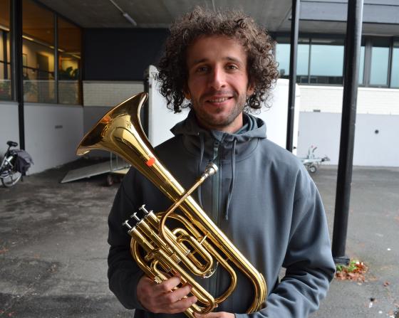 Ung mann som holder trompet p&aring; loppemarked