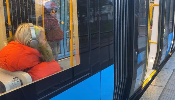 person som sitter p&aring; trikken med headset