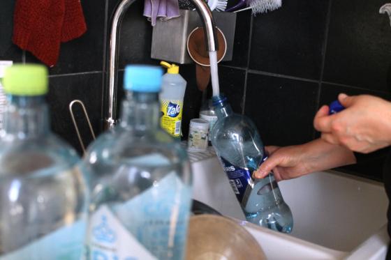 Vannflaske som fylles p&aring; i en vask p&aring; et kj&oslash;kken.