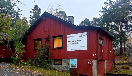 R&oslash;dt trebygg med et stort hvitt skilt der det st&aring;r  Holmlia N&aelig;rmilj&oslash; og Frivilligsentral