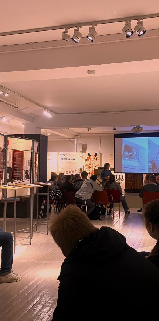 forsamling som h&oslash;rer p&aring; et tidsvitne fortelle om holocaust