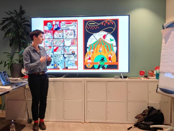 Dominika Miklar st&aring;r foran TVen og holder en presentasjon om den nye boken hennes. 