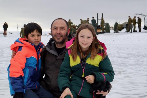 En far med sin s&oslash;nn og datter med kanoner og uniformerte menn i bakgrunn