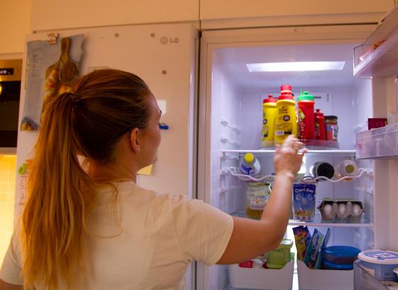 En dame viser fram et snurrebrett i kj&oslash;leskapet hennes med ketsjup og diverse sauser p&aring;.