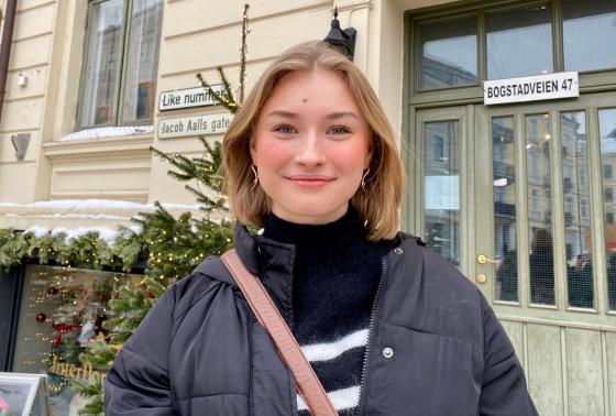 portrett utend&oslash;rs av Live Lislerud Vestli. Hun st&aring;r foran en d&oslash;r. 