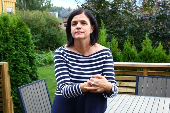Tove Bj&oslash;rgaas sitter p&aring; et bord p&aring; terrassen med hagen i bakgrunnen