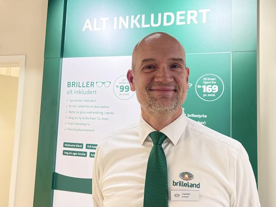 Portrett av optiker Carsten foran gr&oslash;nn vegg p&aring; Brilleland