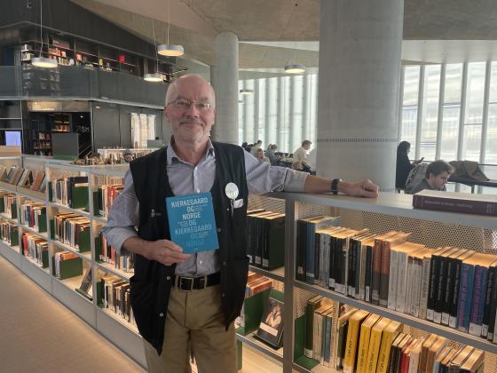 Olav Kapperud poserer foran filosofib&oslash;ker p&aring; Deichman.