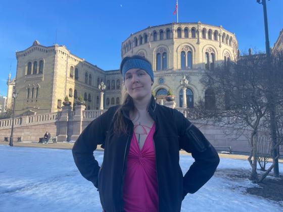 Dame som st&aring;r foran Stortinget