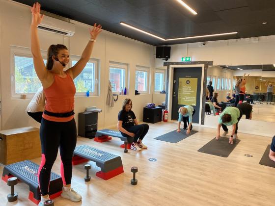 Ida Cecilie Juhasz som er instrukt&oslash;r for seniorer p&aring; Lia treningssenter smiler med armene i v&aelig;ret under gruppetimen