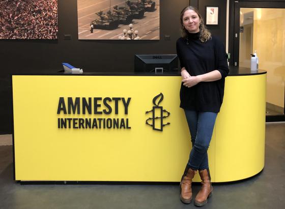 Ingrid Westgaard Stolpestad st&aring;ende foran inngangen til kontoret hos Amnesty.