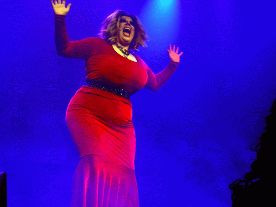 Dragartisten Monetta Leone syng p&aring; scena i raud kjole. 